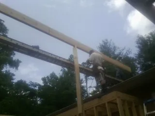 Carpenter setting a ridge beam over a new addition frame — Ice Dam Removal by Roofing Brothers in Old Greenwich