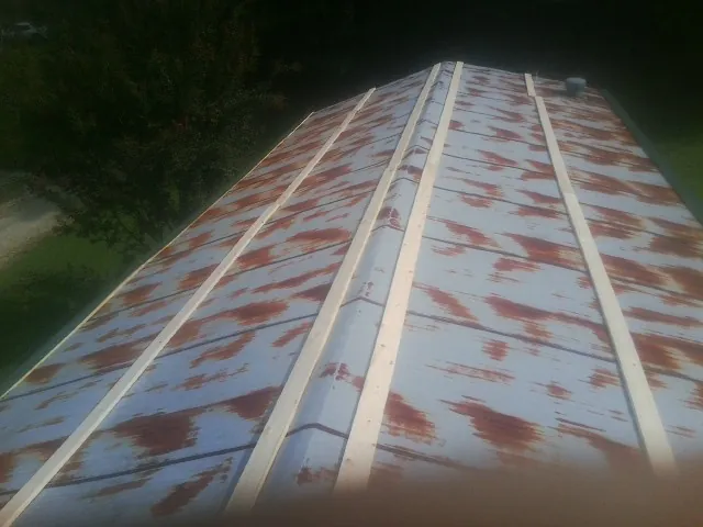 Rusted metal roof panels with new wood purlins before replacement — Storm Damage Roof Repair in Old Greenwich by Roofing Brothers