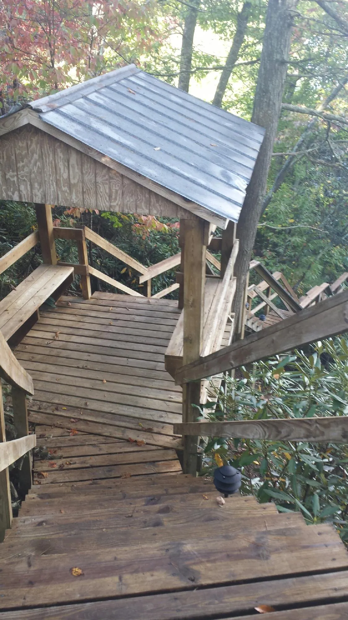 Metal roofed shelter over wooden steps on a wooded walkway — Skylight Repair & Installation work by our crew in Old Greenwich